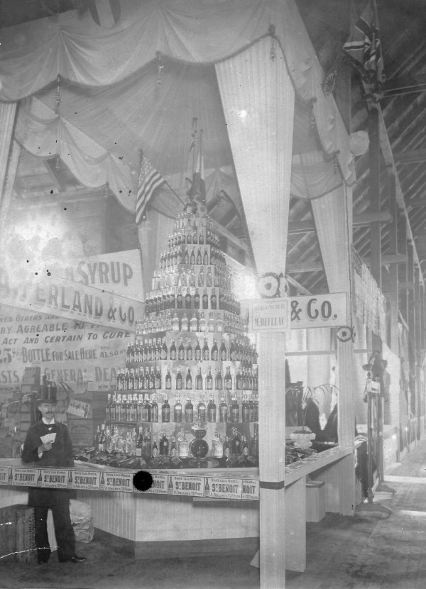 Albert Ferland devant le kiosque des Eaux minérales Saint-Benoit à l'exposition de Montréal, vers 1894
