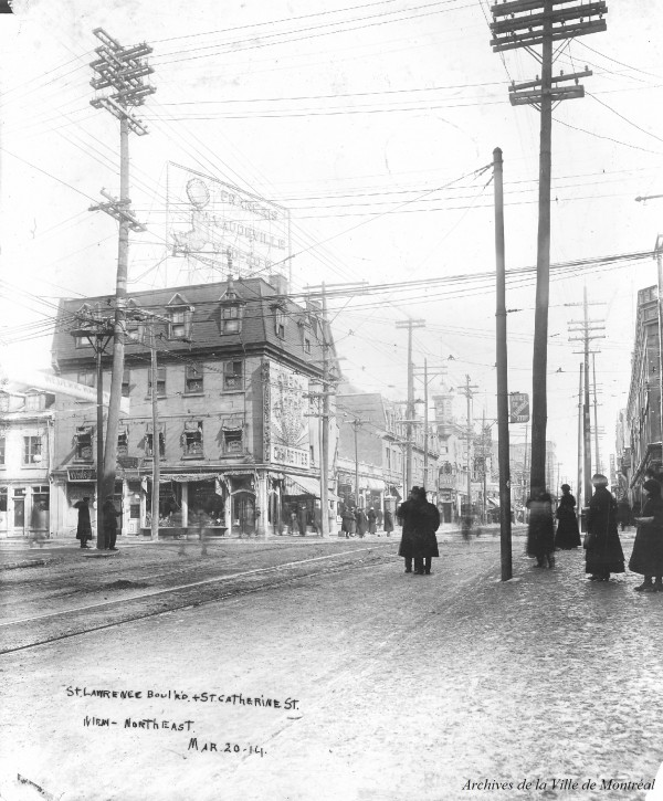Rue Sainte-Catherine à l'angle du boulevard Saint-Laurent avant l'enfouissement des fils électriques, 20 mars 1914, VM98-Y_2P027