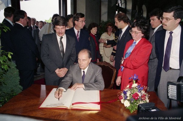 Le président de la France François Mitterand signe le livre d'or de la Ville de Montréal au chalet du mont Royal, 27 mai 1987