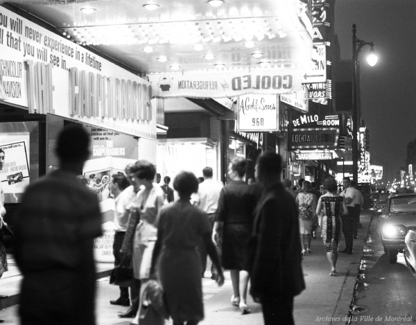 Rue Sainte-Catherine le soir. – 12 juillet 1964. Photo par Maurice Macot. VM94-A0159-009. Archives de la Ville de Montréal.