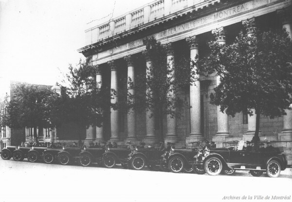 Flotte automobile des policiers devant la Bibliothèque de la Ville de Montréal. 1924. VM94-Z1870-2. Archives de la Ville de Montréal.