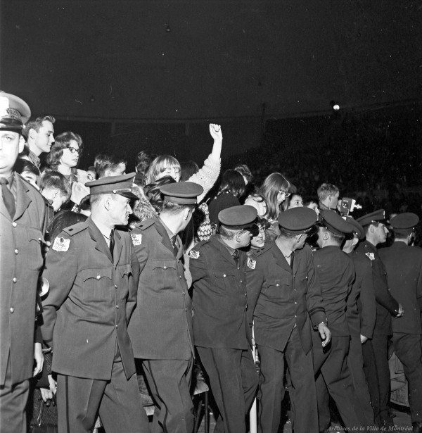 Cordon de sécurité pour contenir la foule au concert des Beach Boys, aréna Maurice-Richard. 19 février 1965. VM94-S32-002. Archives de la Ville de Montréal.