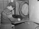 Un employé de RCA Victor vérifie le recouvrement d'or de la copie originale d'un disque . 3 octobre 1944. Photo de Conrad Poirier. P48,S1,P10519. BAnQ.