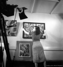 La peintre Rita Letendre posant un tableau au mur lors du tournage du film « Artistes à Montréal » de Jean Palardy.  – Avril 1954. Photographie de Robert Millet. P179-Y-01-02-D003-P064. AVM.