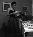 L’écrivaine et actrice Thérèse Renaud, debout, avec sa fille et son mari, le peintre Fernand Leduc, assis à table, chez eux. – Novembre 1954. Photographie de Robert Millet. P179-Y-01-02-D003-P127. AVM.
